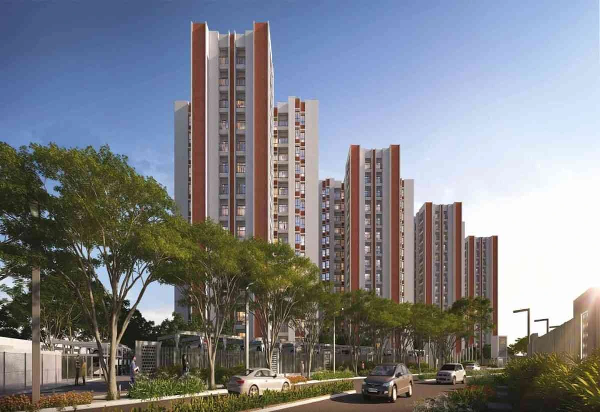 Front view of DTC Capital City Crest featuring modern high-rise residential towers, landscaped greenery, and driveway with vehicles.