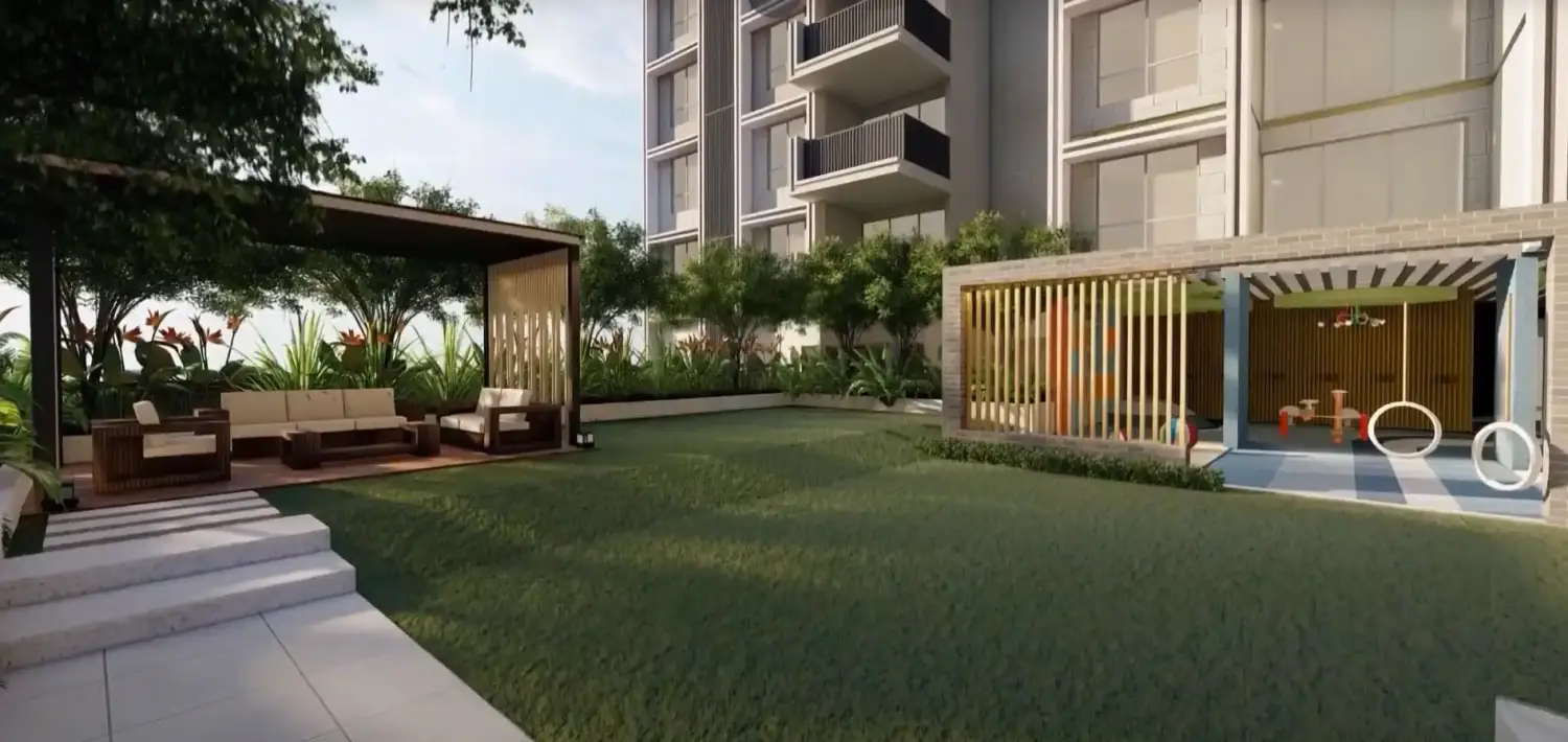 Landscaped garden area at Purti Tatsam featuring outdoor seating, shaded pavilion, greenery, and adjacent children’s play zone.
