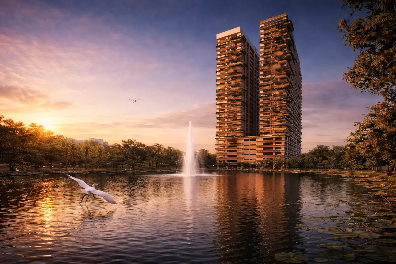 Sunset view at Udyatt overlooking landscaped gardens, swimming pool, and modern high-rise apartment towers with an open city skyline.