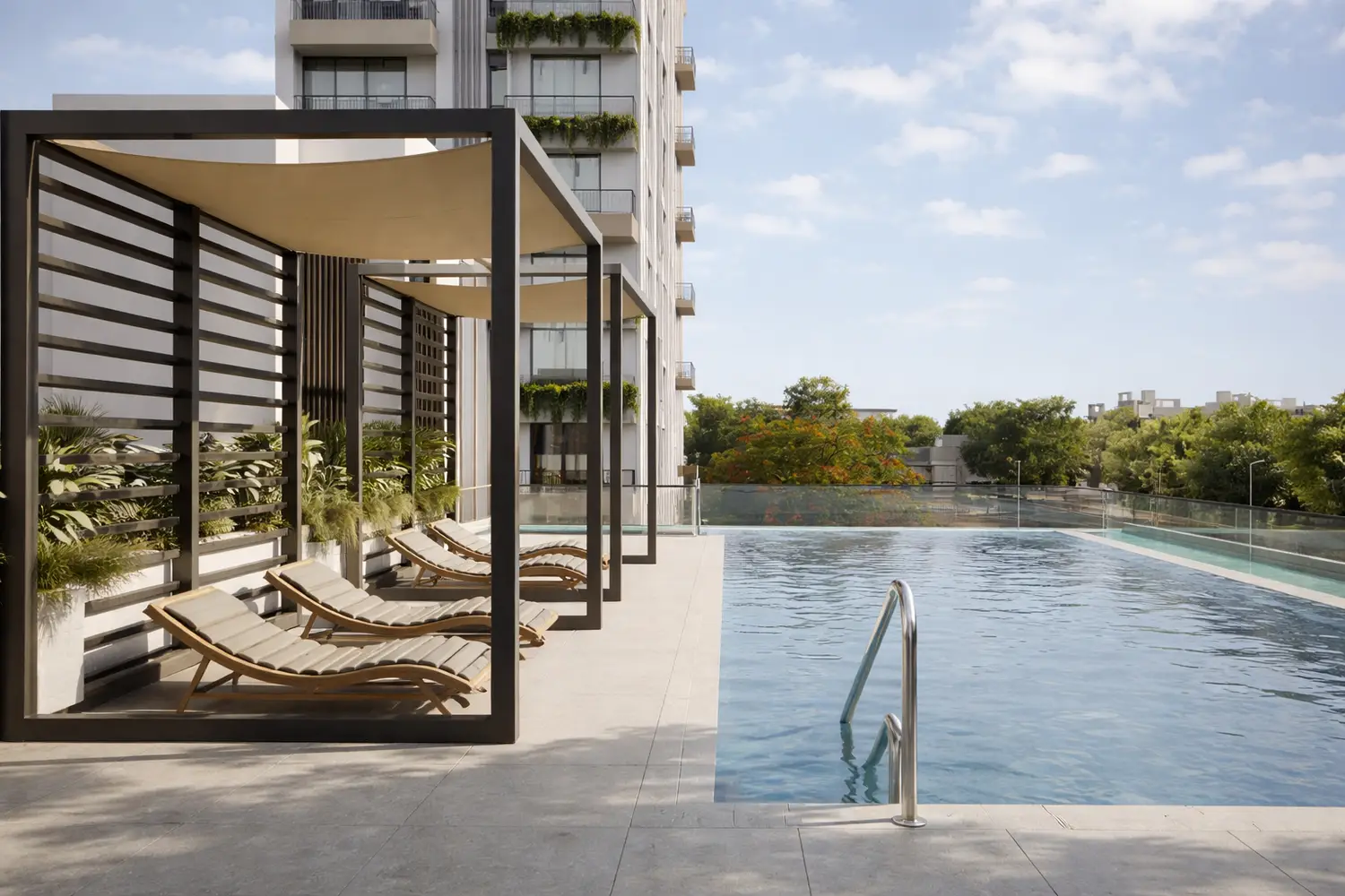 Primarc Aahana luxury residential project in Kolkata featuring a modern rooftop swimming pool, poolside loungers, landscaped greenery and premium leisure amenities