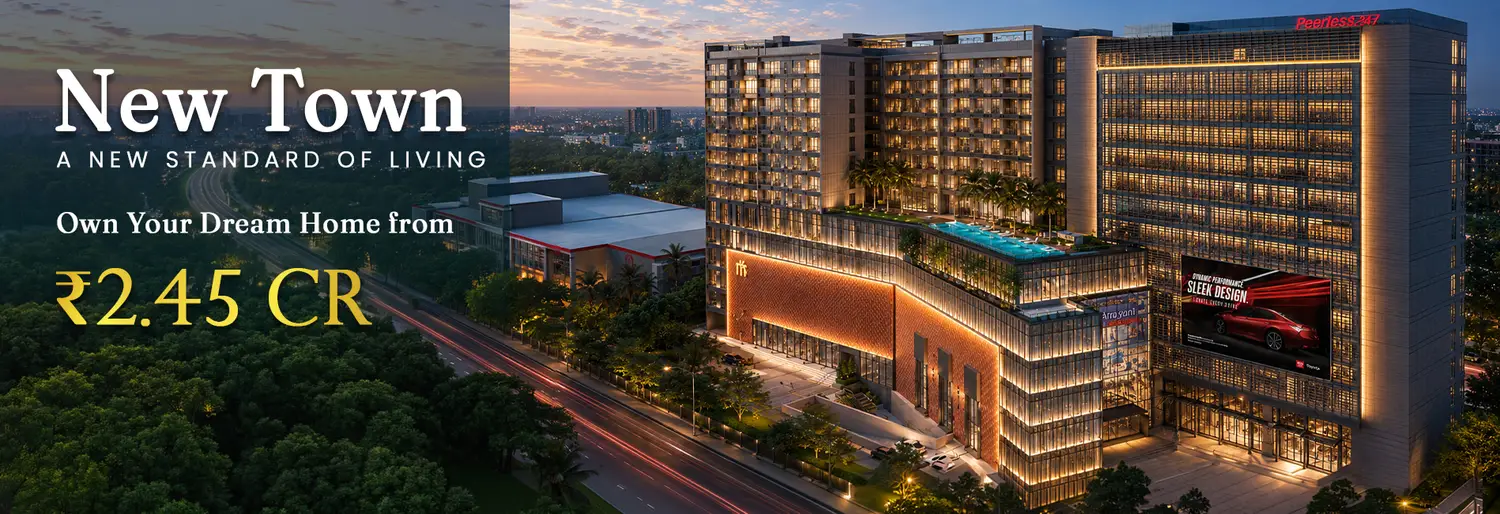Peerless Trayam premium residential and commercial development in New Town, Kolkata, featuring a modern illuminated building, rooftop swimming pool, landscaped surroundings, and a cityscape at dusk.