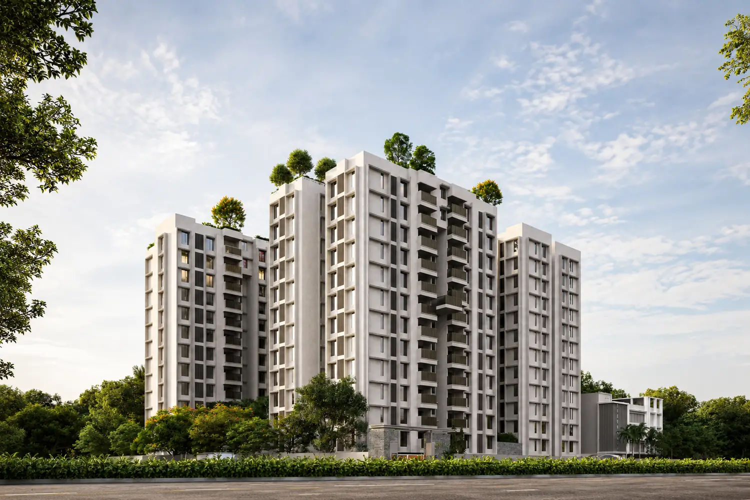 Purti Tatsam residential development featuring contemporary multi-storey apartment towers with balconies, landscaped greenery, rooftop trees, and a landscaped roadside setting under a bright blue sky.